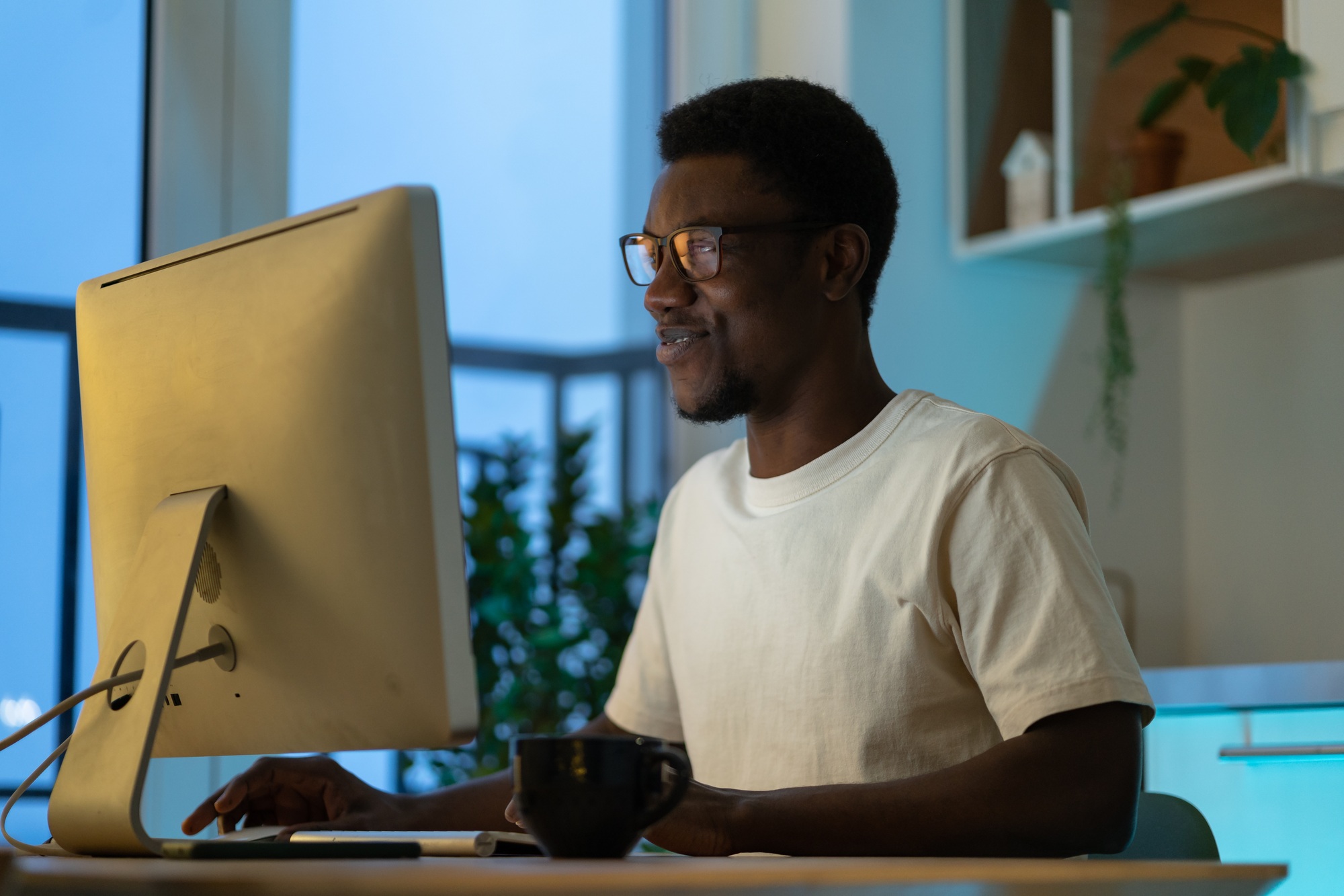 Successful software engineer coding on computer at home late at night enjoy overtime work on startup